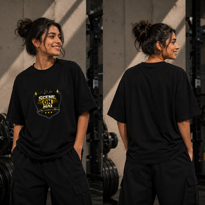 A woman modeling a black oversized T-shirt in a gym setting, shown from both the front and back. The front features a yellow and white graphic shield design with the text 'SCENE ON HAI'.