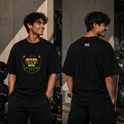 A man modeling a black graphic t-shirt in a gym setting, showing both front and back views. The front features a yellow and black 'SCENE ON HAI' graphic, and the back has a small white 'ea' logo.